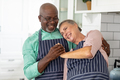 Happy senior multiracial couple enjoying in kitchen at home - PhotoDune Item for Sale