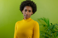 Portrait of beautiful young african american female advisor with afro hairstyle against green wall - PhotoDune Item for Sale
