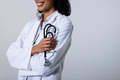 Midsection of smiling african american mid adult female doctor wearing lab coat holding stethoscope - PhotoDune Item for Sale
