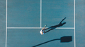 Directly above view of young caucasian female player playing on blue tennis court during sunny day - PhotoDune Item for Sale