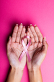 Hands of african american mid adult woman holding pink breast cancer awareness ribbon, copy space - PhotoDune Item for Sale