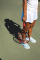 Low section of african american female athlete standing with tennis racket at court on sunny day - PhotoDune Item for Sale