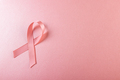 Directly above shot of pink breast cancer awareness ribbon against pink background, copy space - PhotoDune Item for Sale