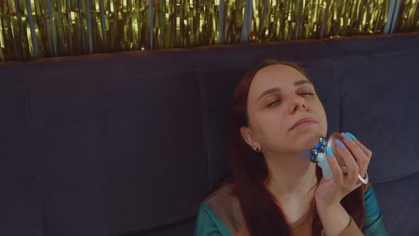 Young Woman Using 3d Massager for Face