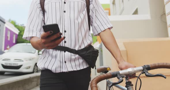 Mixed race man walking with a bike