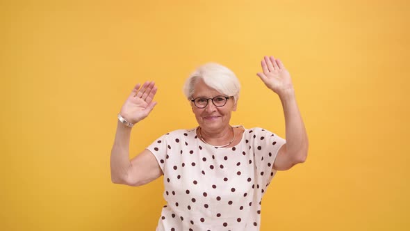 Senior Lady Dancing in Slow Motion, Isolated on the Orange Background