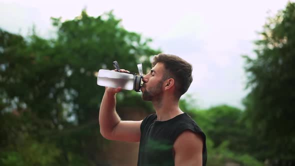 Portrait of Sport Man Drinking Mineral Water After Outdoor Workout