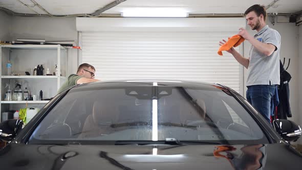 Two Specialist Dries the Car From Moisture Car Washing at Detailing Service