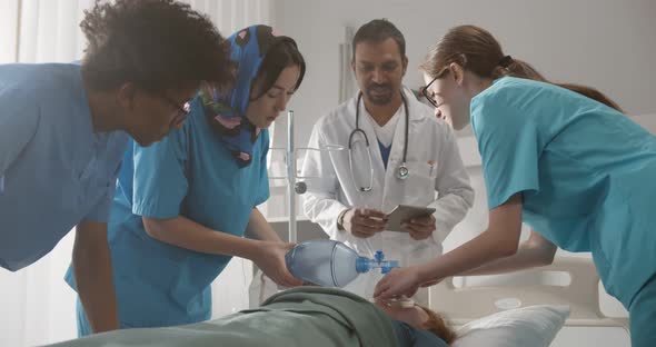 Multiethnic Team of Doctors Putting Oxygen Mask on Patient in Hospital