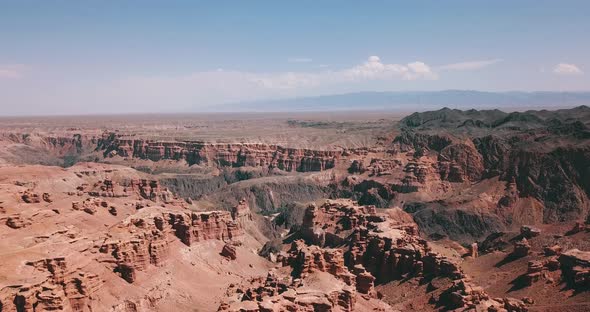 The Grand canyon is red. Around steppe, sky and dark rocks.