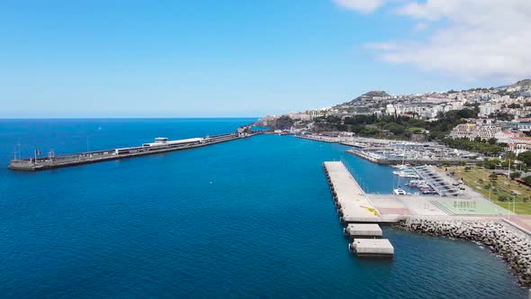 Drone aerial pan right view of Atlantic Ocean and the harbor in Funchal city, Madeira island in Port