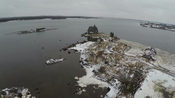 Flying over old wooden house in the sea