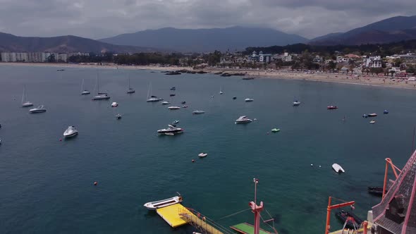 Seascape adorned with boats, yachts, speedboats, harbor and lighthouse facing beaches.