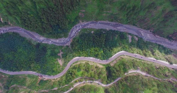 Aerial view of a curved winding roads trough the forest with river, Beautiful nature and transportat