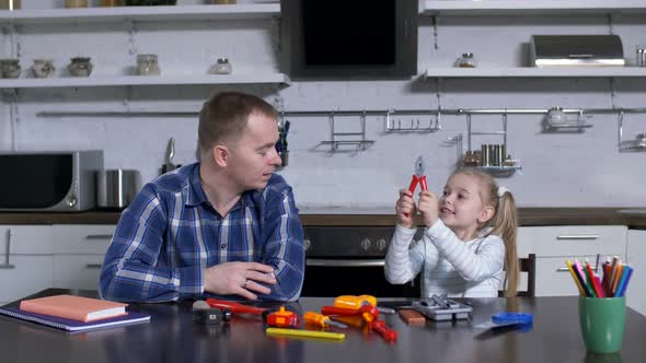 Girl Showing Dad Pliers During Home Craft Lesson