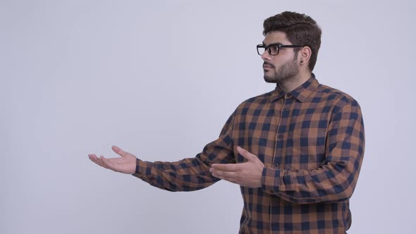 Happy Young Bearded Indian Hipster Man Showing Something