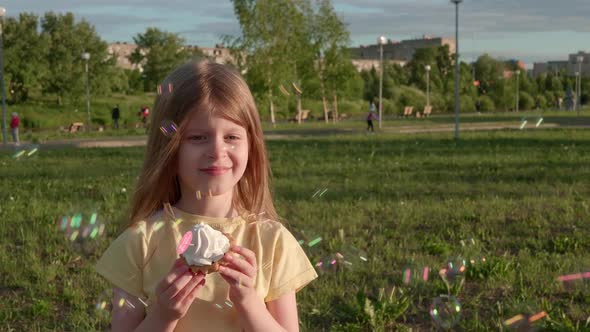 Happy Child Girl with Birthday Cake in Soap Bubbles Outside