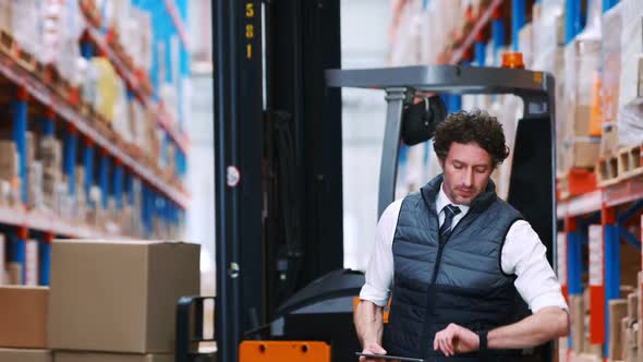 Male warehouse worker using digital tablet