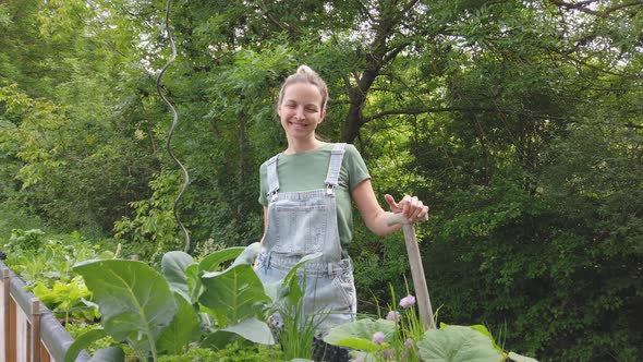 Slow motion shot of smiling gardener at raised bed