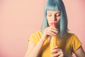 Hipster young woman with red lipstick and blue dyed hair drinking orange juice - PhotoDune Item for Sale