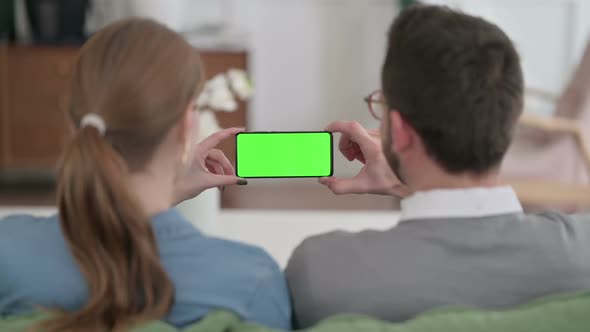 Rear View of Couple Holding Smartphone with Green Chroma Key Screen