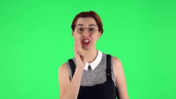 Portrait of Funny Girl in Round Glasses Is Screaming Calling Someone. Green Screen