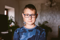 Portrait of caucasian boy wearing eyeglasses at home - PhotoDune Item for Sale