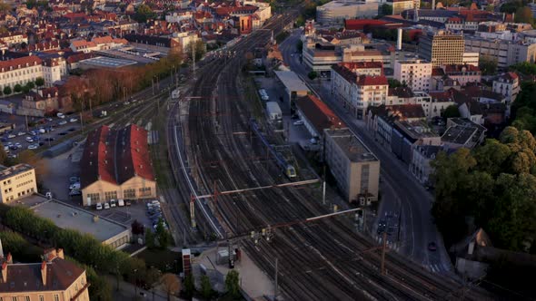 Europe train entering city on tracks drone follow shot at golden hour 4k 30p