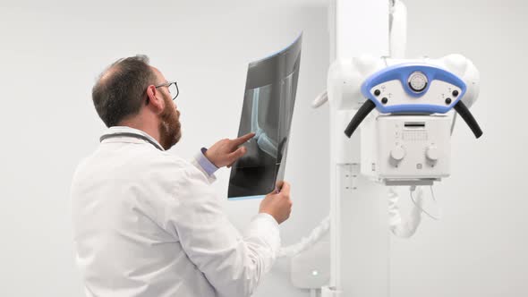 Doctor Examine a Film Xray of a Patient at Radiology Room