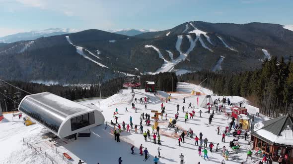 Aerial View Crowd of Skiers Skiing on Peak Ski Slope Near Ski Lifts. Ski Resort