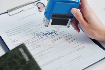 consular officer in embassy approving visa application putting seal on it
