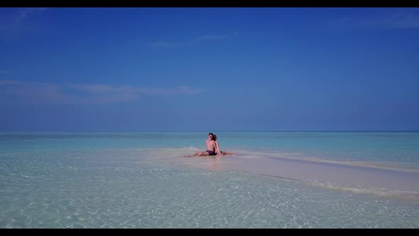 Boy and girl posing on idyllic lagoon beach trip by blue ocean and white sandy background of the Mal