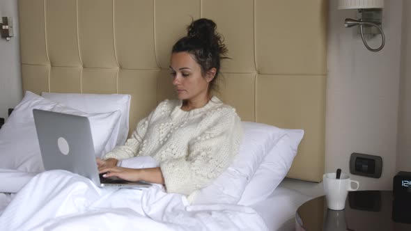 Woman Work on Laptop Computer and Sit on Bed