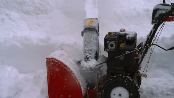 Man with a Snow Blowing Machine Working