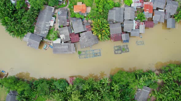 An aerial view over a fishing village by a canal in the countryside