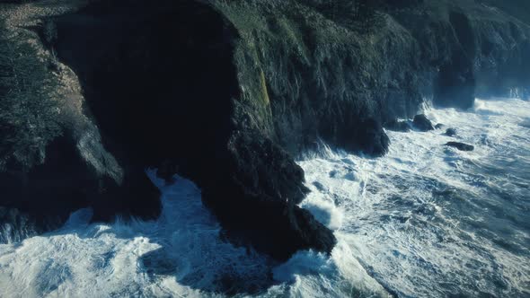 Drone Floating Over Coastline Rocks With Sea Waves Splashing Slow Motion