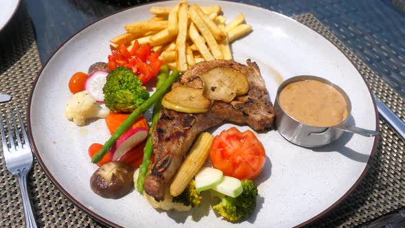 Pork Chop Serve with Vegetables French Fries and Pepper Sauce
