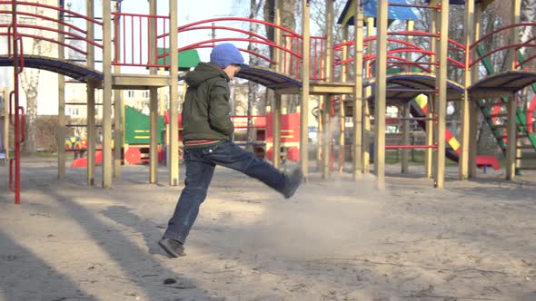 Wide Shot of Upset Caucasian Little Boy Spending Spring Day Alone on Playground