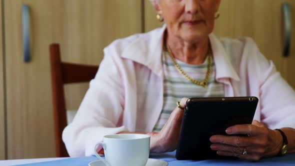 Senior woman using digital tablet at table 4k