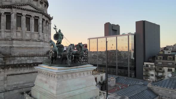 Aerial orbit around bronze quadriga monument and Argentine Congress Palace dome at golden hour, Buen