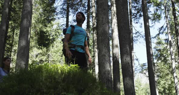 Woman Photographer Shooting Photos with Man Friend in Sunny Forest