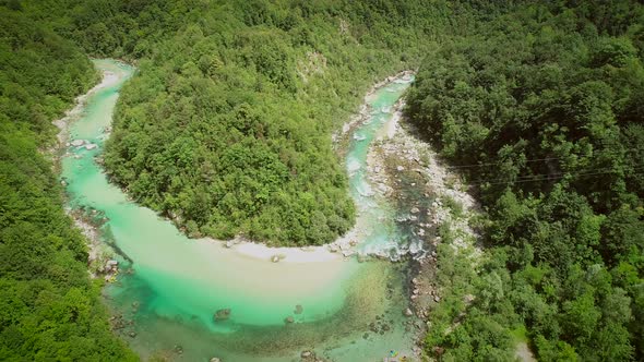 Aerial view of the calm water surrounded by nature at Soca river in Slovenia.