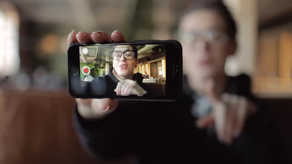 Young Blogger Recording Video on Smartphone