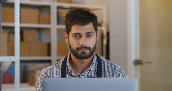 Portrait of Bearded Male Manager Working on Laptop in Warehouse