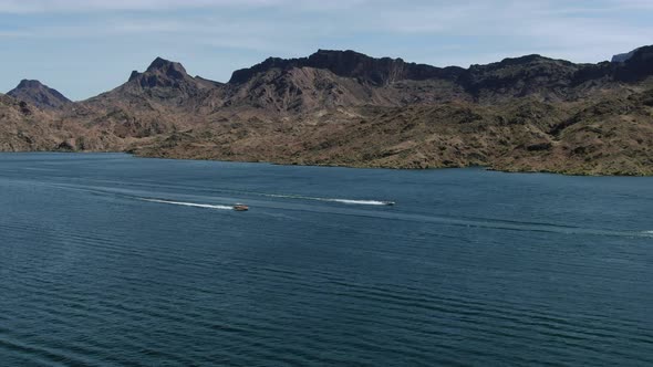 High-res 4K drone footage shows two fast boats racing full speed across lake Havasu in the summer ha