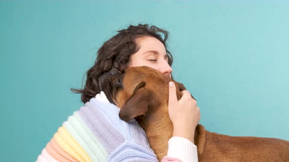 Woman stroking and hugging her boxer dog. Animals and pets concept.