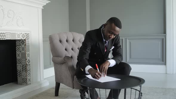 Black Businessman in an Expensive Interior Sits in an Armchair in a State of Sadness