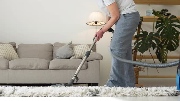 Senior Woman Vacuuming Carpet at Home