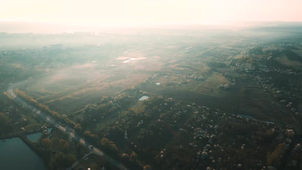 Aerial View of an Asphalt Road Between Agricultural Fields and a Lake