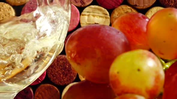 Pouring wine into a glass against the background of wine corks.	